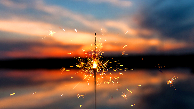 Sparkler in front of a sunset.